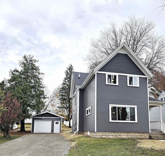 view of side of property with a garage, an outbuilding, and a lawn