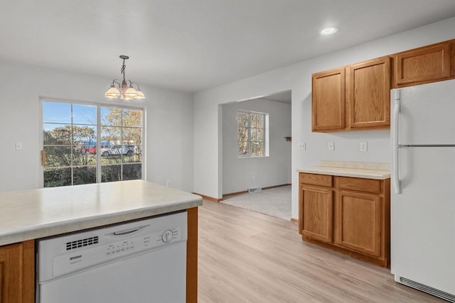 kitchen featuring white appliances, a chandelier, decorative light fixtures, and a wealth of natural light