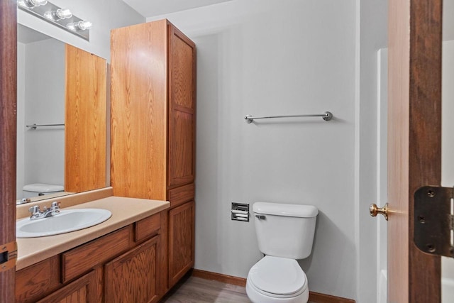 bathroom featuring toilet, vanity, and hardwood / wood-style flooring