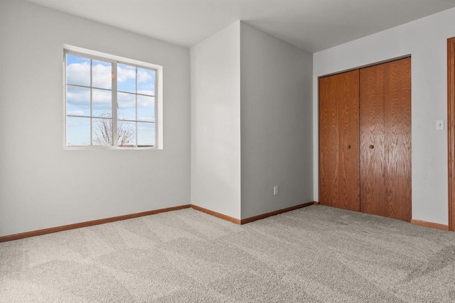 unfurnished bedroom featuring a closet and light carpet