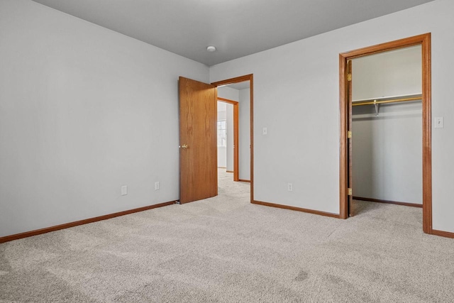 unfurnished bedroom featuring light carpet and a closet