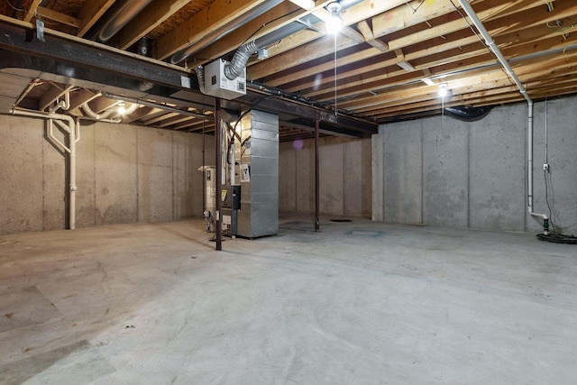 basement featuring water heater and heating unit