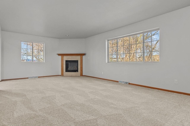 unfurnished living room featuring carpet and a tile fireplace