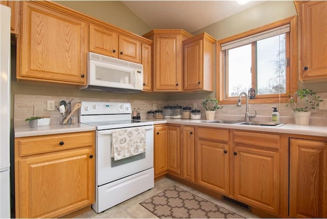 kitchen featuring vaulted ceiling, a textured ceiling, tasteful backsplash, sink, and white appliances