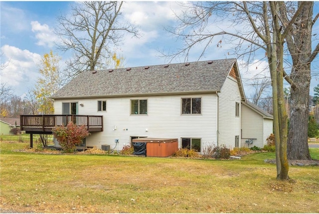 back of property featuring a hot tub, central air condition unit, a yard, and a deck