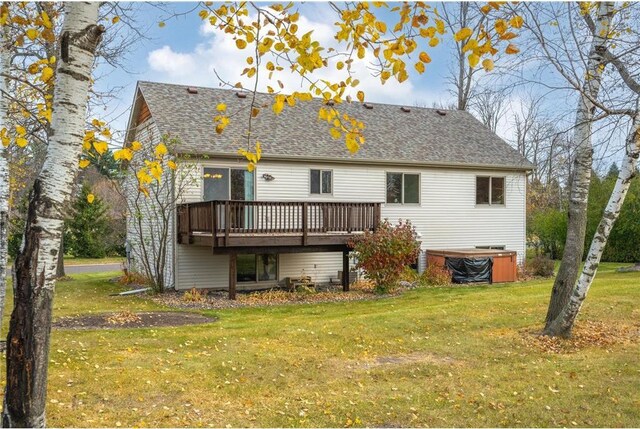 rear view of property featuring a deck and a lawn