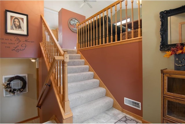 stairs with ceiling fan and crown molding