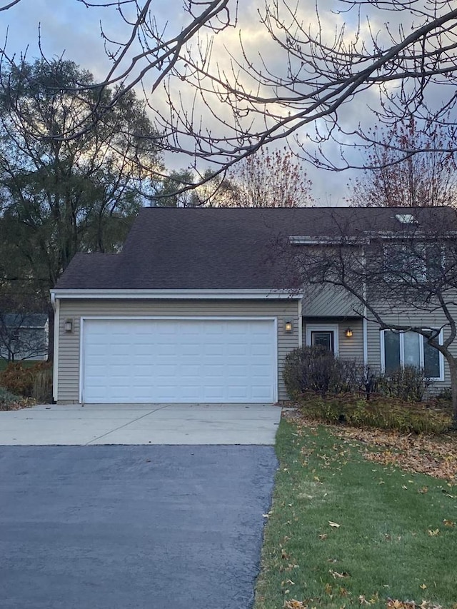 single story home featuring a garage and a yard