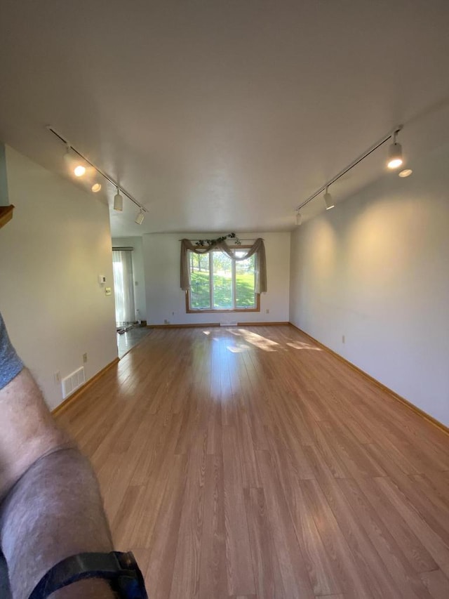 unfurnished living room with light hardwood / wood-style flooring and rail lighting