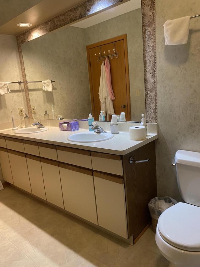 bathroom featuring toilet, vanity, and tile patterned flooring