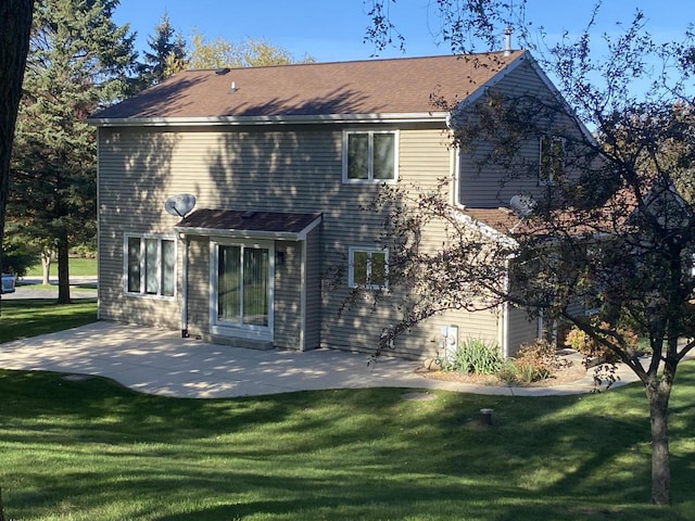 rear view of house with a lawn and a patio area