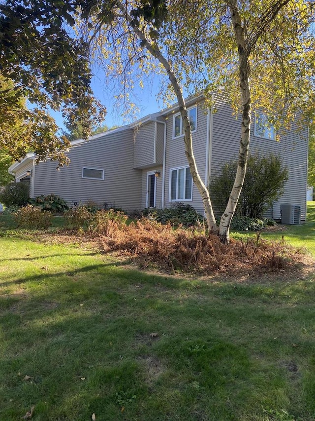 exterior space featuring cooling unit and a lawn