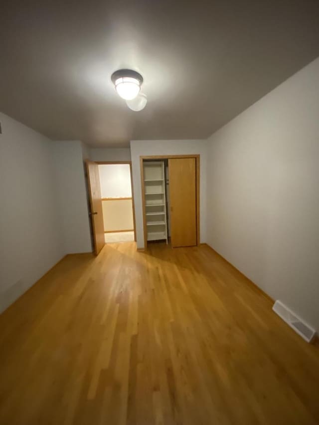 unfurnished bedroom with a closet and hardwood / wood-style floors