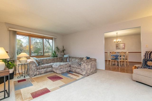 carpeted living room featuring a notable chandelier