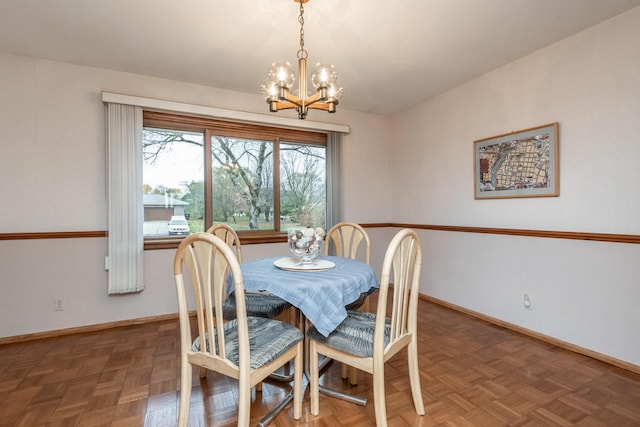 dining area with a chandelier and dark parquet flooring