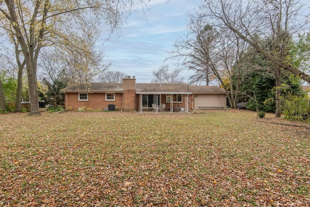 rear view of property featuring cooling unit and a yard