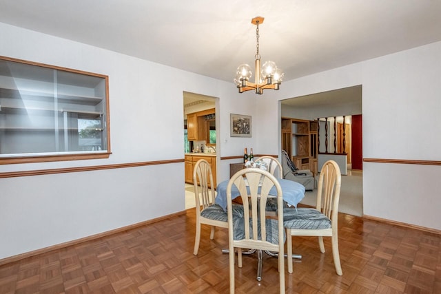 dining area with a notable chandelier and dark parquet flooring