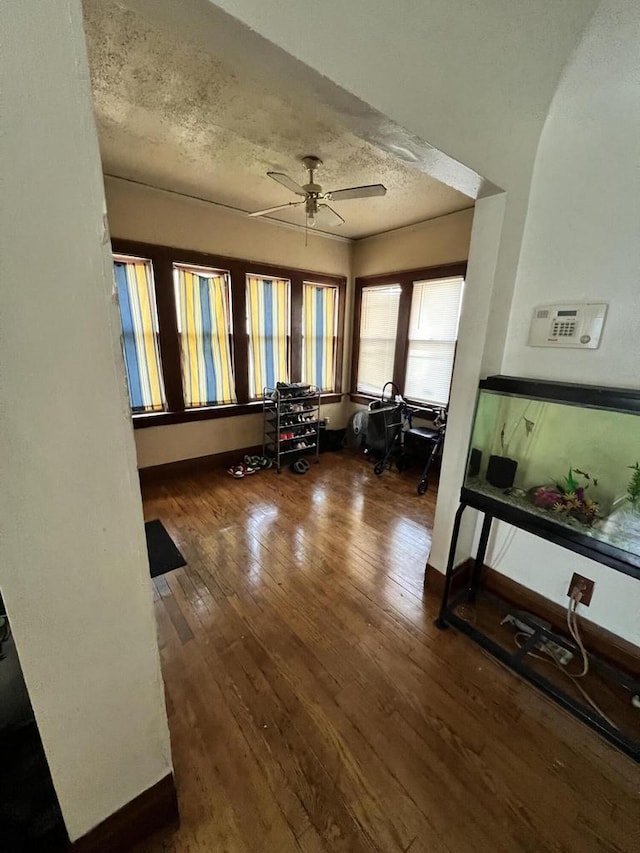 interior space with ceiling fan, dark hardwood / wood-style floors, and a textured ceiling