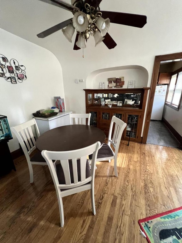 dining space with wood-type flooring and ceiling fan