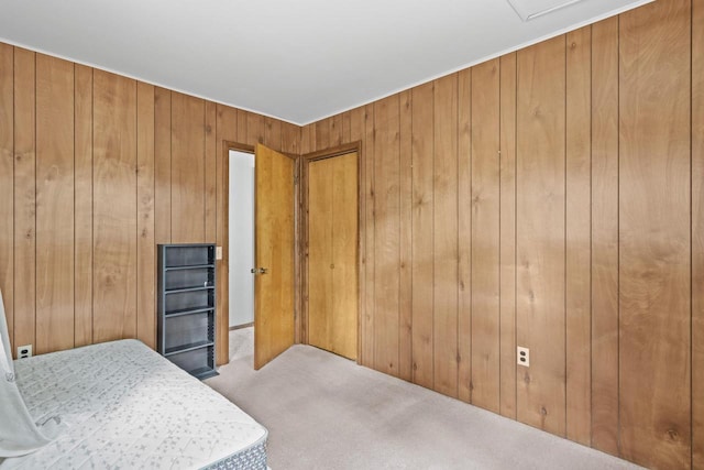 carpeted bedroom featuring wood walls