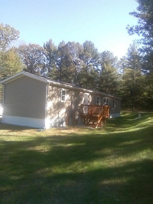 rear view of property with a deck and a lawn