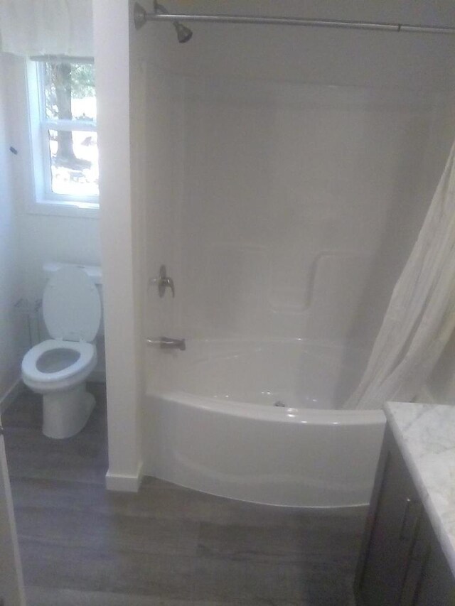 full bathroom with vanity, hardwood / wood-style floors, shower / tub combo with curtain, and toilet