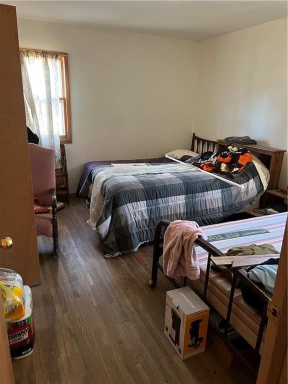 bedroom with dark hardwood / wood-style flooring