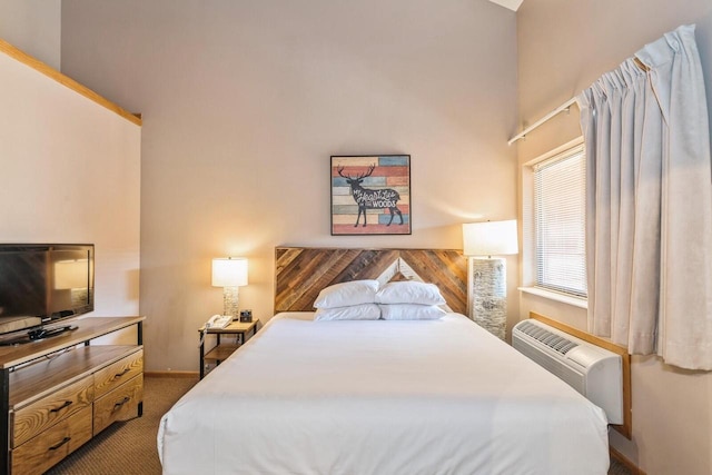 bedroom featuring a wall mounted air conditioner and dark carpet