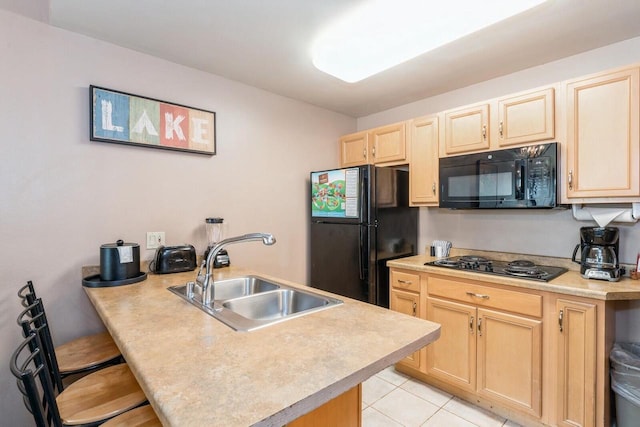 7020 Grand Geneva Way Unit 159, Lake Geneva, WI 53147 - kitchen with black appliances, a sink, a peninsula, light brown cabinets, and light countertops