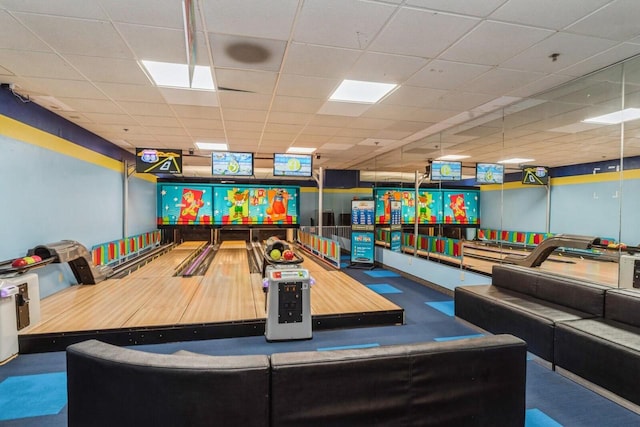 playroom with bowling and a drop ceiling