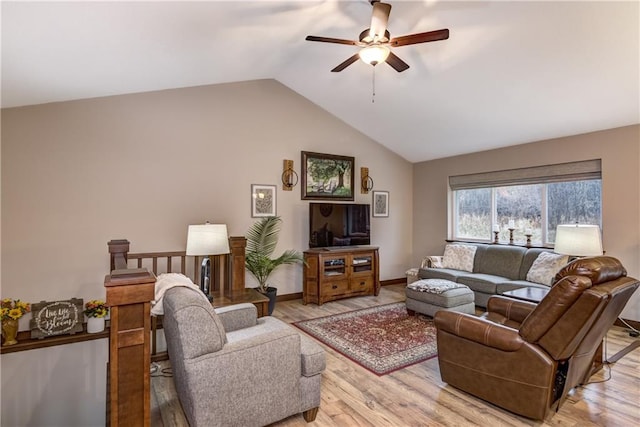 living room with light hardwood / wood-style floors, ceiling fan, and vaulted ceiling