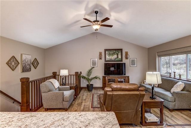 living room with ceiling fan, light hardwood / wood-style flooring, and vaulted ceiling