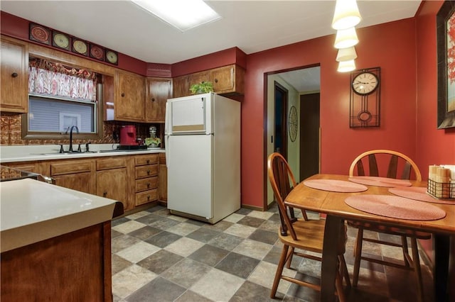 kitchen with sink, white refrigerator, and decorative backsplash