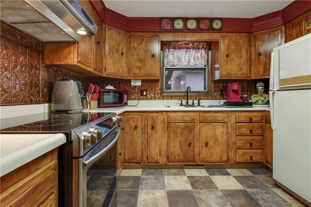 kitchen featuring decorative backsplash, sink, white refrigerator, and stainless steel electric stove