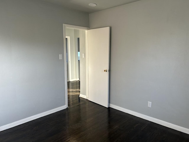 spare room with dark wood-type flooring