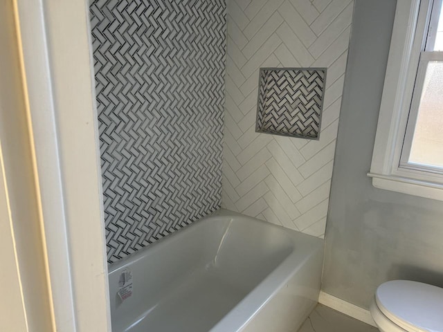 bathroom featuring a washtub and toilet