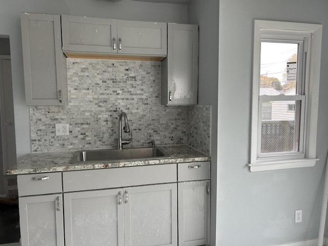 kitchen featuring gray cabinetry, decorative backsplash, and sink