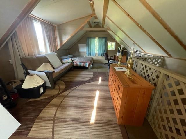 bonus room featuring hardwood / wood-style floors and vaulted ceiling with beams