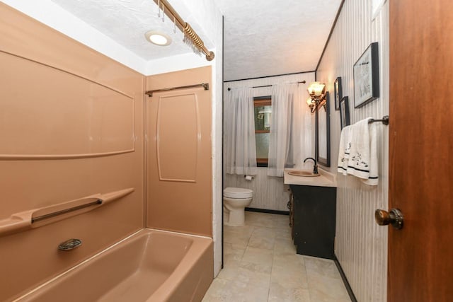 bathroom with vanity, toilet, and a textured ceiling