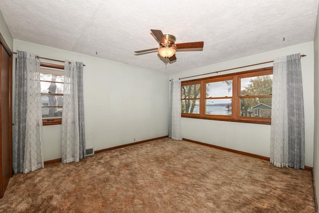 unfurnished room featuring carpet, a textured ceiling, and ceiling fan