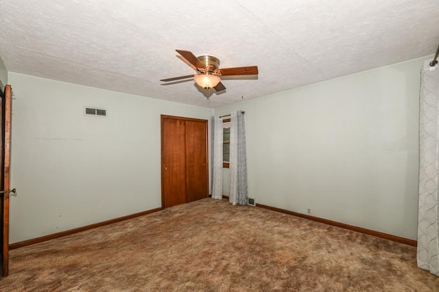 carpeted empty room featuring a textured ceiling and ceiling fan