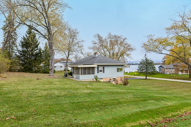 view of side of property with a sunroom and a yard