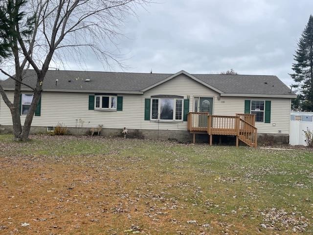 back of house featuring a wooden deck and a yard