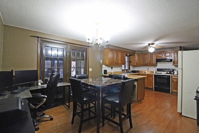 dining space with dark hardwood / wood-style floors, a textured ceiling, sink, and ceiling fan with notable chandelier