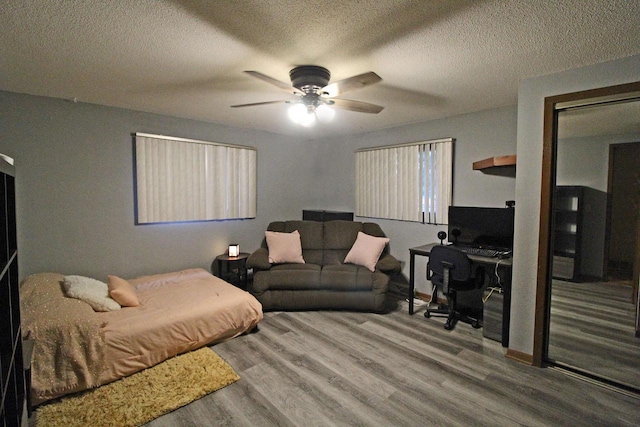 bedroom featuring a textured ceiling, wood-type flooring, and ceiling fan