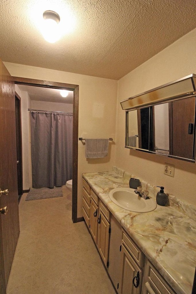 bathroom featuring vanity, a textured ceiling, toilet, and a shower with curtain