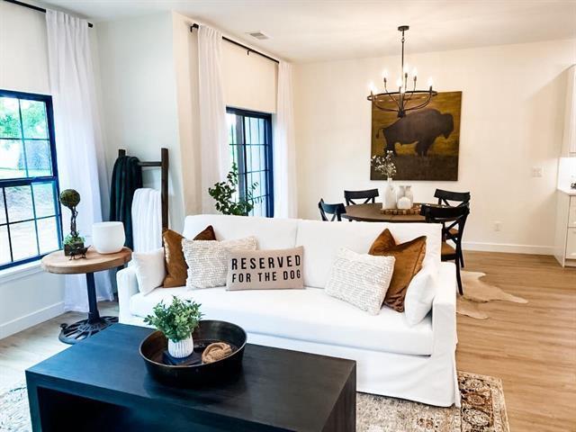 living room with a notable chandelier and light hardwood / wood-style flooring