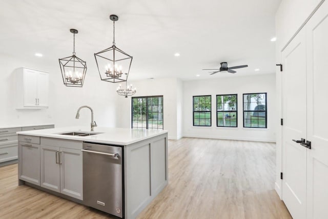 kitchen featuring sink, stainless steel dishwasher, an island with sink, pendant lighting, and gray cabinets