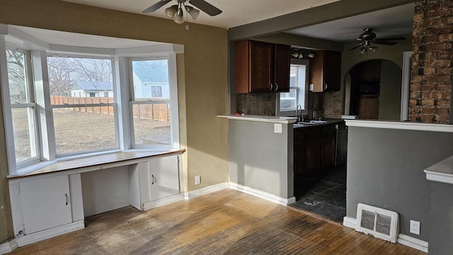 kitchen featuring tasteful backsplash, dark brown cabinetry, a wealth of natural light, and wood-type flooring