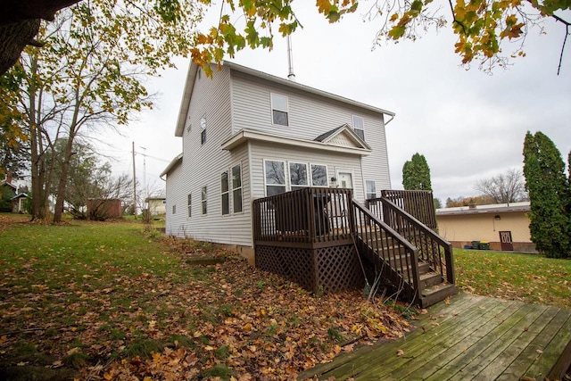 rear view of house featuring a lawn and a deck